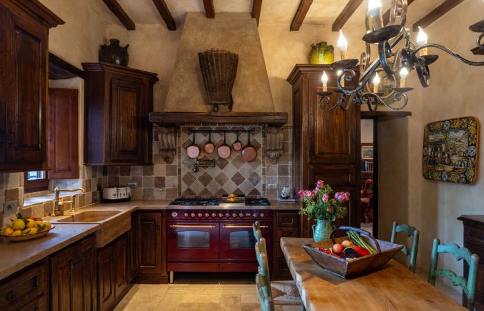 Modern kitchen with six-burner range, double ovens, full fridge and dishwasher.